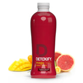 Detoxify Mega Clean botella en mesa, lista para uso diario