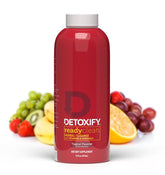 Detoxify Ready Clean Tropical: botella derramando para acción rápida de desintoxicación.