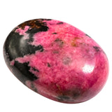 Amazing Gemstone Rhodonita, primer plano de piedra palma para relajación y armonía emocional.