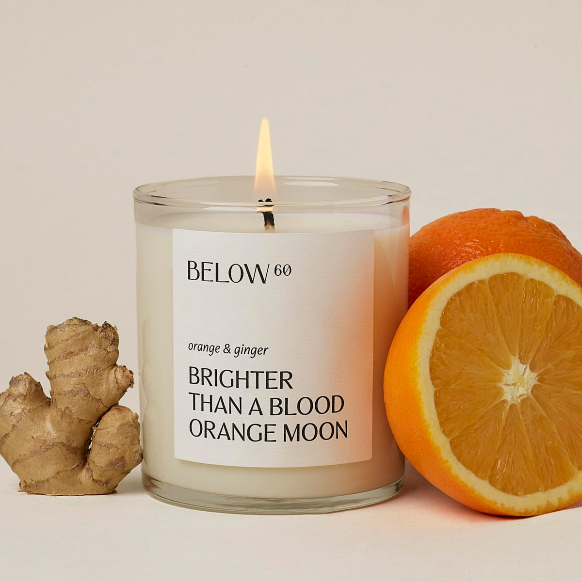 Vela Below 60 naranja y jengibre encendida para despertar la energía.