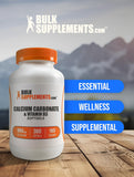 BulkSupplements calcio-d3-softgels-mano-sosteniendo-botella: demostración de tamaño y empaque.