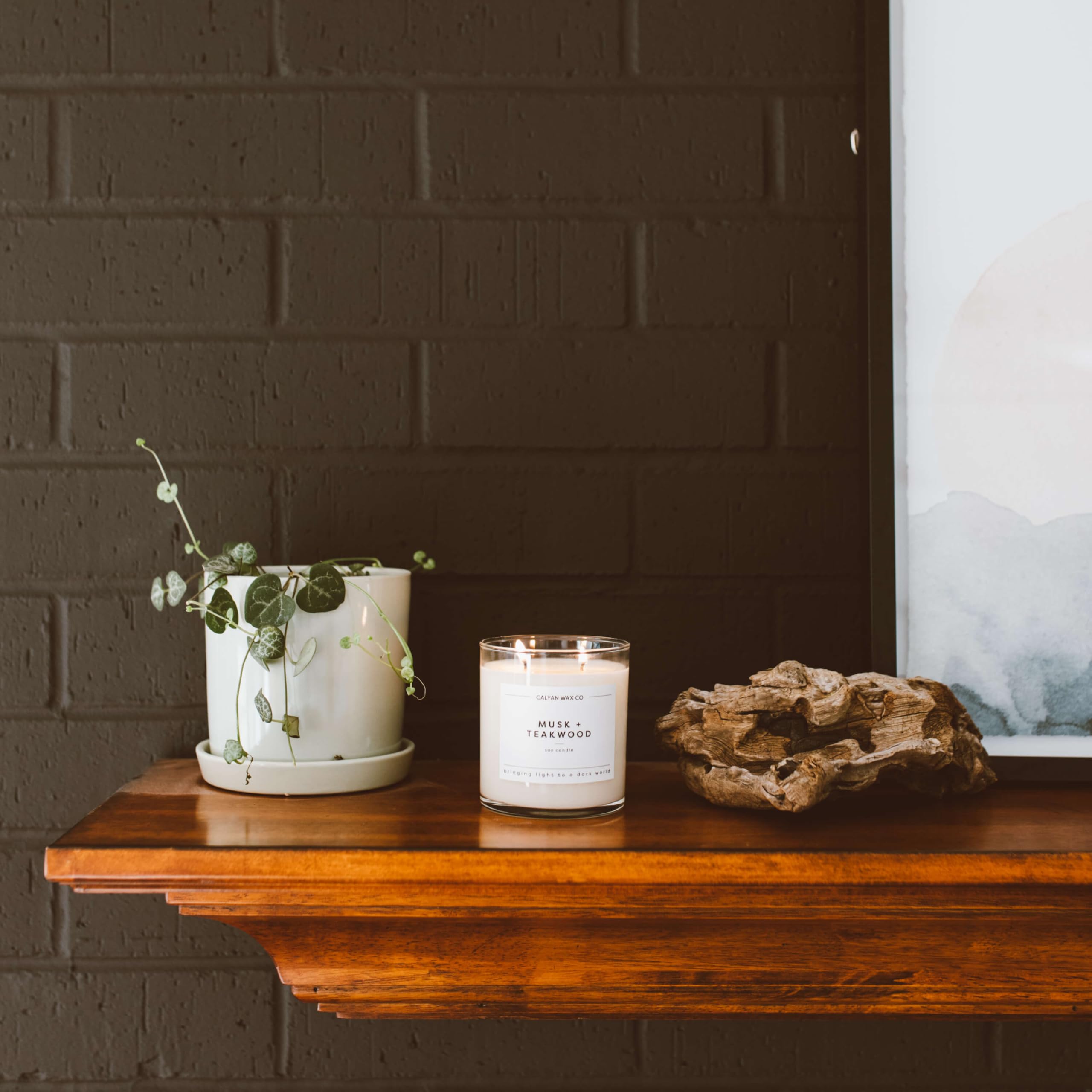 Calyan Wax Co. Tarro de cristal con vela Musk-Teakwood, iluminación elegante.