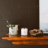 Calyan Wax Co. Tarro de cristal con vela Musk-Teakwood, iluminación elegante.