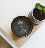 Calyan Wax Co. vela Cedar & Tobacco en dormitorio amplio, creando ambiente relajante.