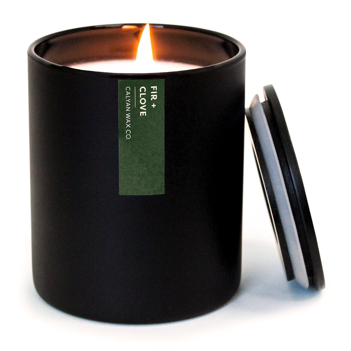 Calyan Wax Co. Vela pino-clavo en vaso negro, aroma cálido y acogedor.