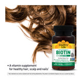 Cápsulas de Country Life Biotina 5 mg en la mano, uso diario recomendado.