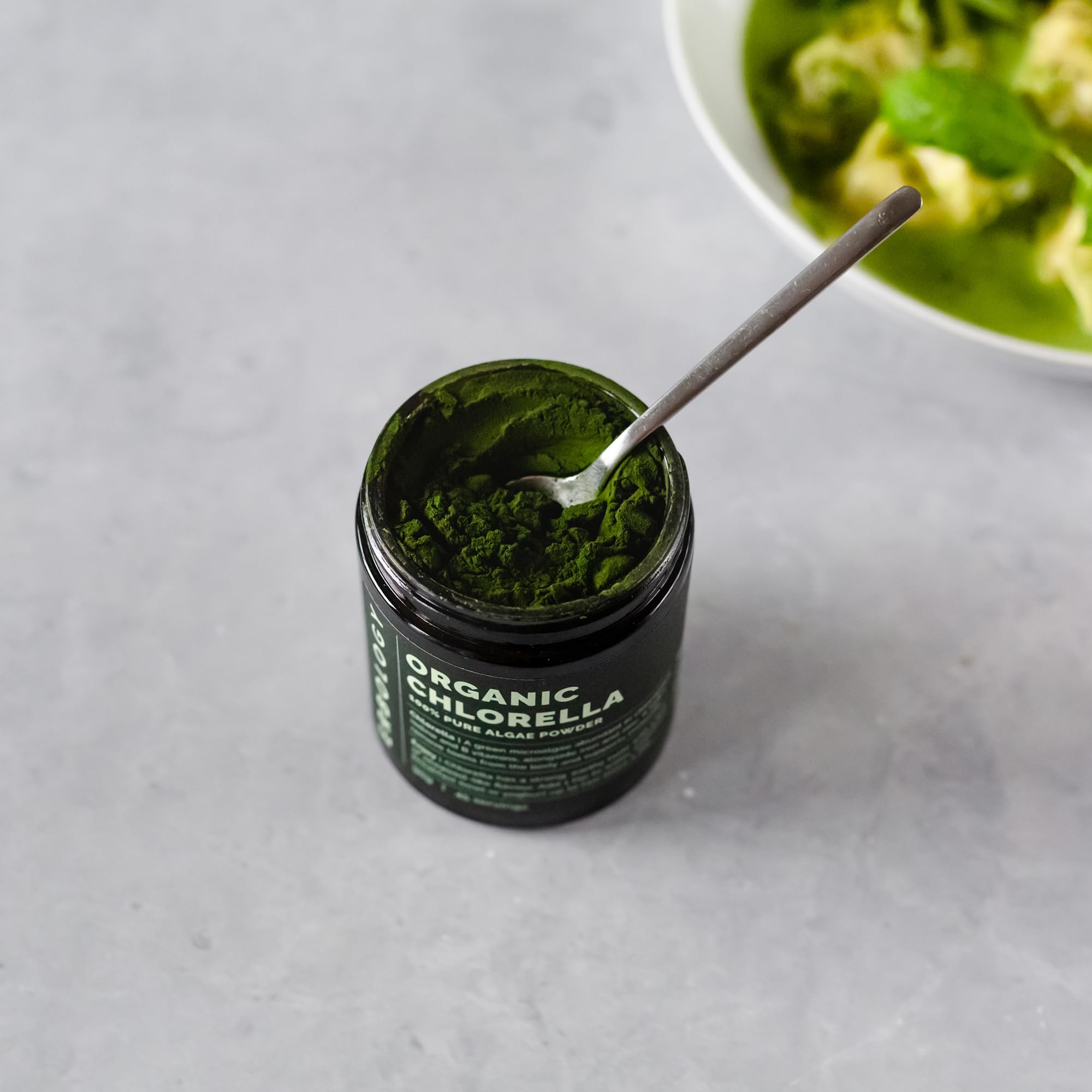 Erbology Chlorella en polvo mezclada en smoothie verde, sabor terroso.