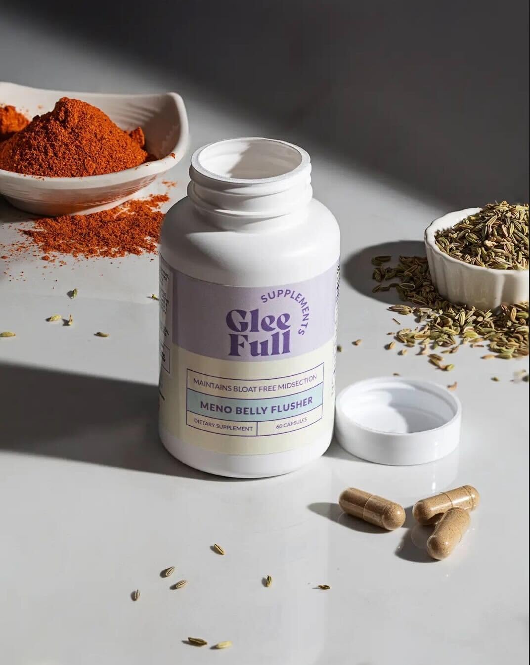 GLEEFULL SUPPS Meno Belly Flusher, cápsulas en mano para comodidad digestiva diaria.