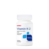 GNC Vitamina K-2 100mcg: botella de cápsulas para apoyar el proceso de construcción ósea.