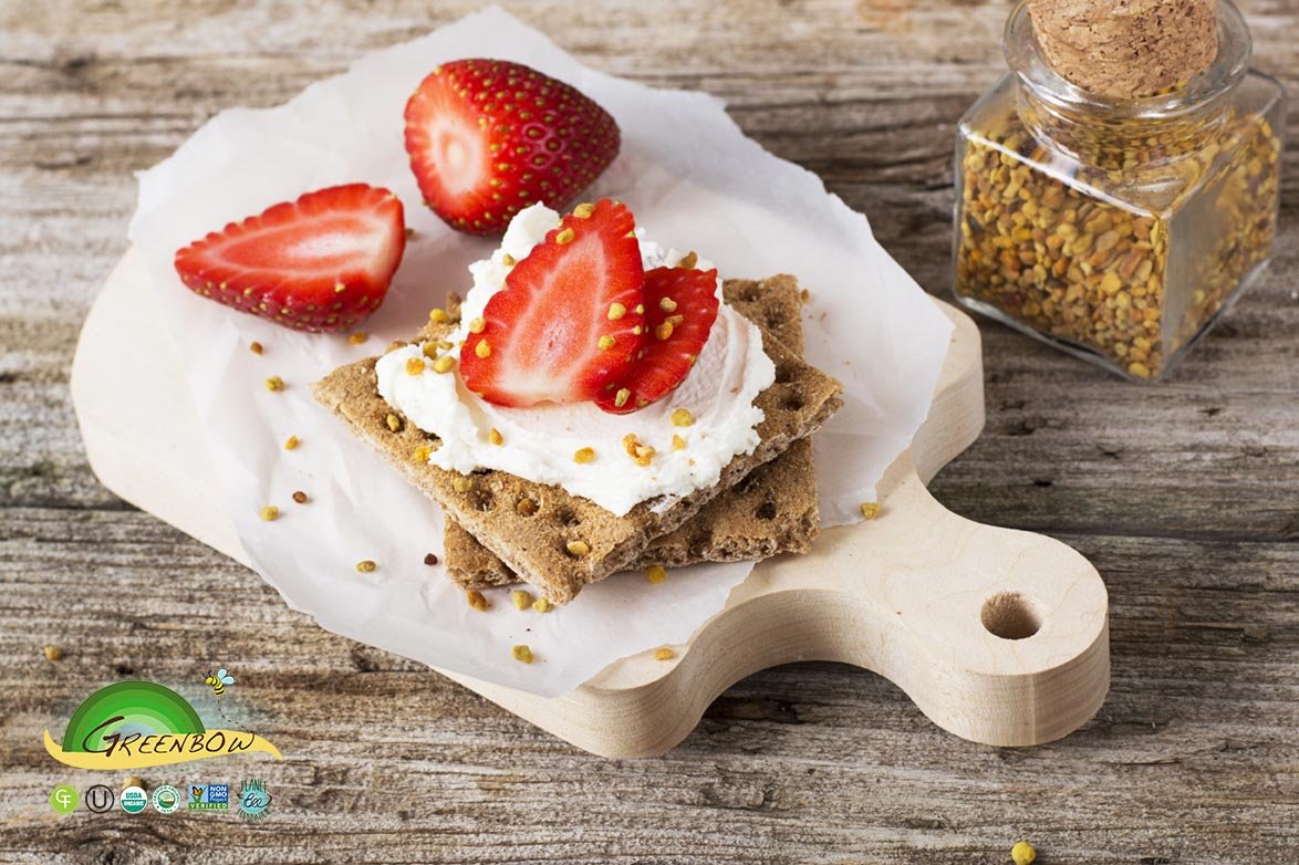 Espolvoreando Greenbow polen de abeja orgánico sobre cereal para energía matutina