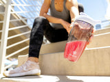 Vaso con bebida frambuesa-limón Isagenix Amped BCAA Plus
