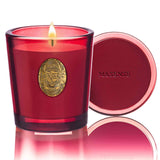 Vela M&SENSE de soja natural con rosa salvaje y rojo iluminando un ambiente cálido