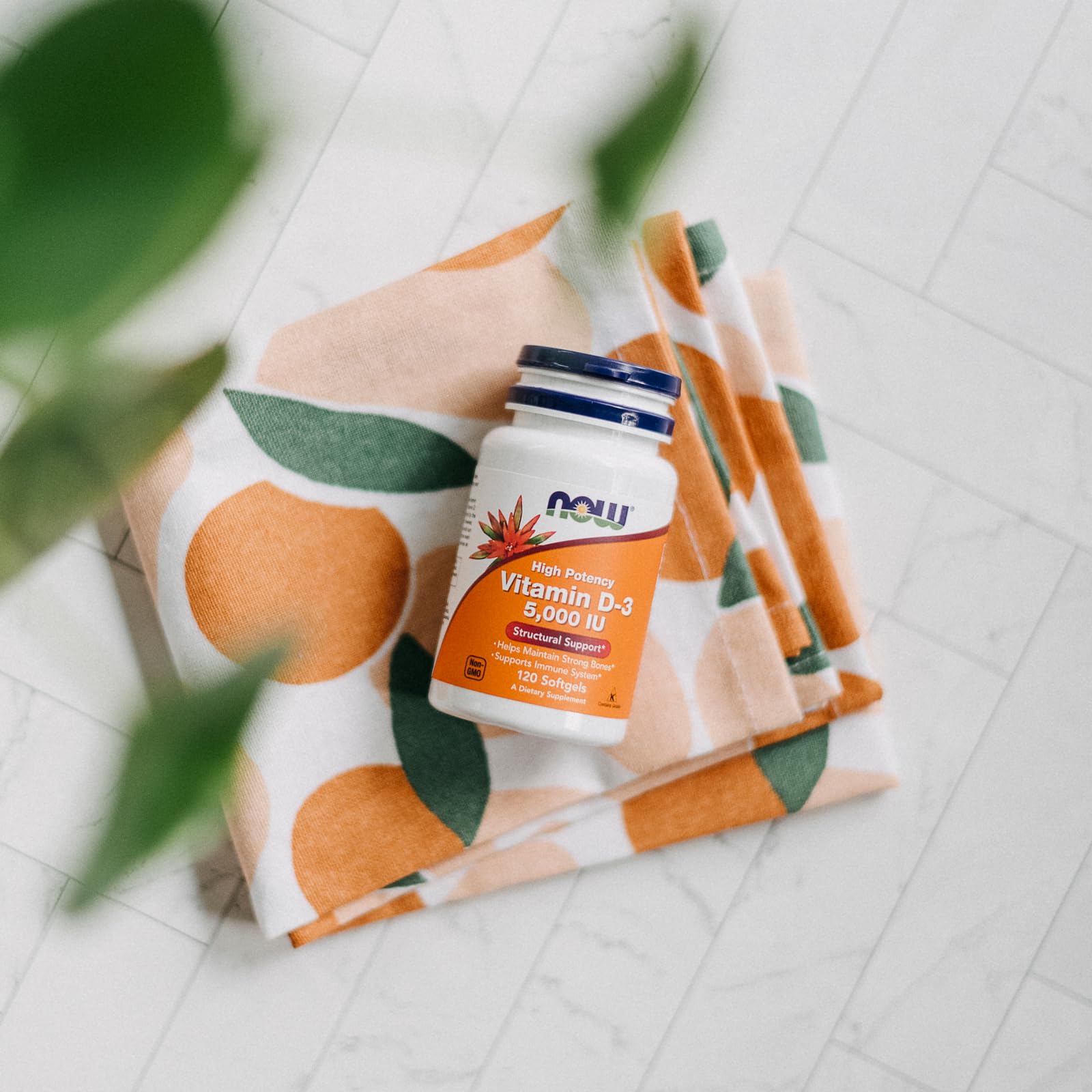 Frasco NOW Foods Vitamina D3, ambiente iluminado, almacenamiento estable