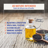 Capsulas de aceite de comino negro en mesa, subraya pureza y formato vegano.
