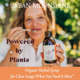 Jarabe Urban Moonshine para pecho claro en copa, uso diario para apoyar la respiración suave.
