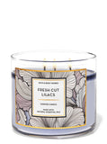 Vela White Barn con tres mechas; lilas frescas perfuman la sala y crean ambiente sereno